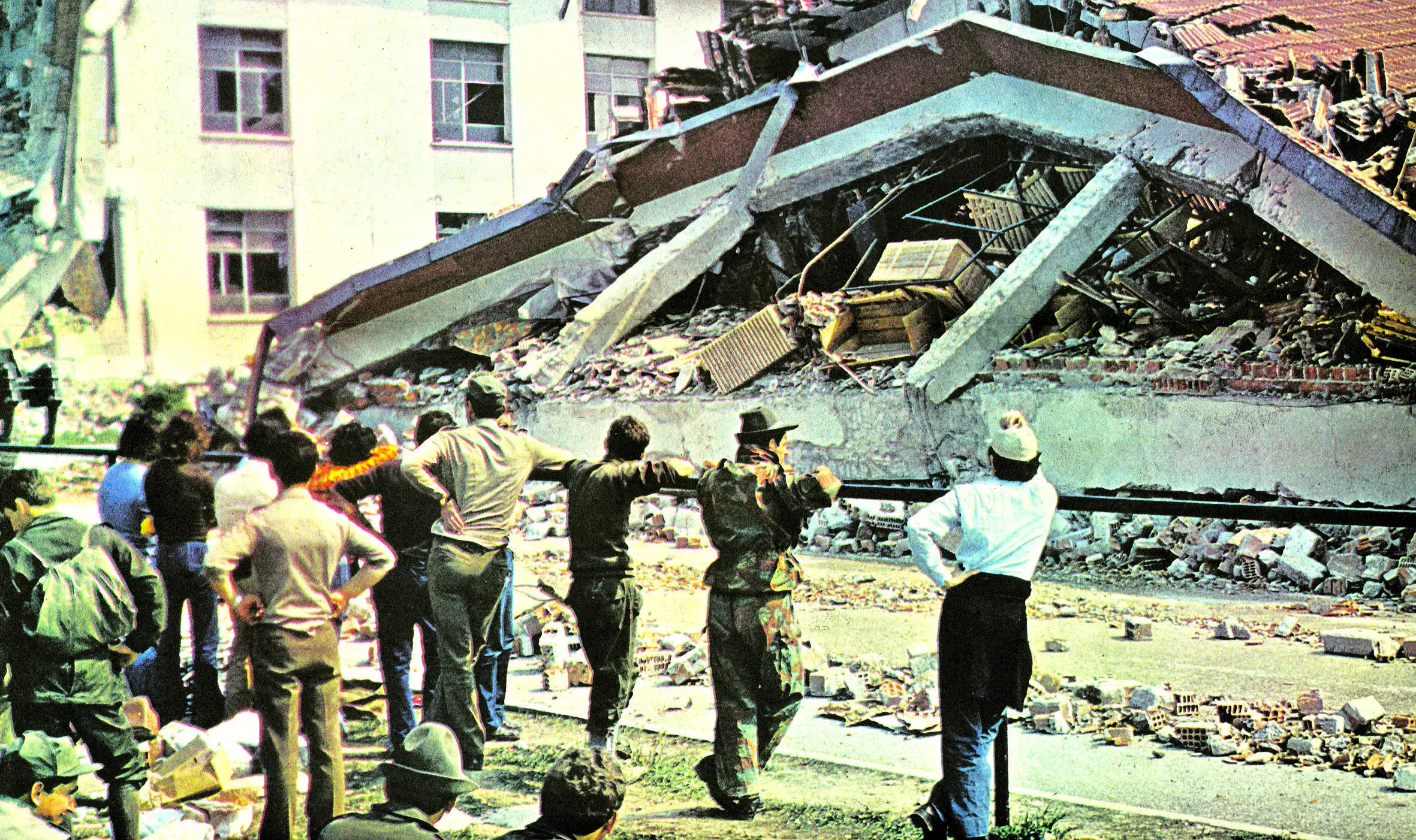 Militari osservano uno dei tre fabbricati della Goi Pantanali distrutti dal sisma il 6 maggio 1976