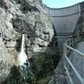 Una veduta della diga del Vajont da valle con la cascata di scarico del by pass e il ponte tubo