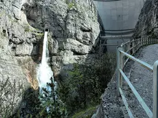 Una veduta della diga del Vajont da valle con la cascata di scarico del by pass e il ponte tubo