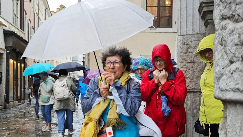 Turisti alle prese con il maltempo nel centro di Trieste (foto Andrea Lasorte)