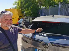 Lodolo mostra il sasso che ha rotto il vetro della sua auto