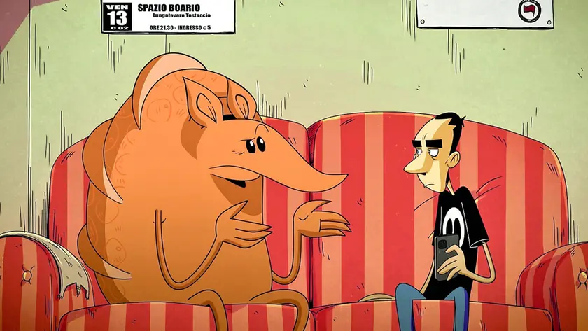 Zercocalcare seduto sul divano con l’Armadillo in i Due spicci