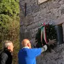La corona d’alloro collocata sotto alla lapide commemorativa a Palcoda