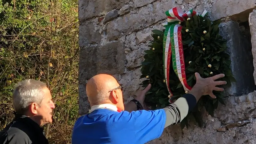 La corona d’alloro collocata sotto alla lapide commemorativa a Palcoda