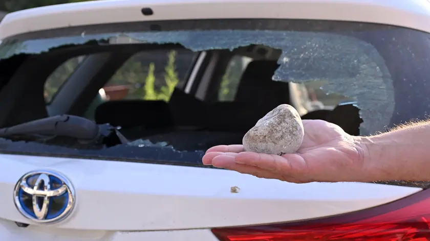 Un’automobile con il vetro spaccato dal lanciodi un sasso