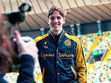 Nicolò Zaniolo sorridente con la tuta dell’Udinese