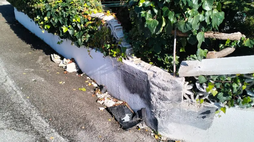 Un muretto di recinzione di una casa danneggiato da un camion