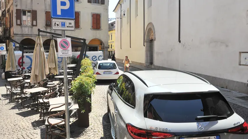 Le auto posteggiate sugli stalli di carico-scarico in via Sarpi
