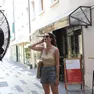 Una ragazza cerca refrigerio davanti a un maxi-ventilatore installato fuori da un locale pubblico