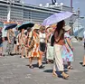 Un gruppo di turisti si protegge dal sole in piazza Unità a Trieste (foto Andrea Lasorte)