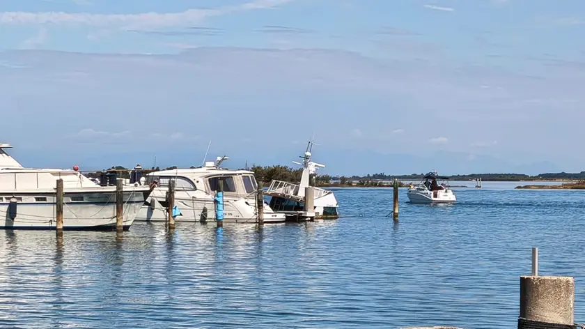 Il motoscafo abbandonato che sta piano piano affondando al pontile di riva Bioni