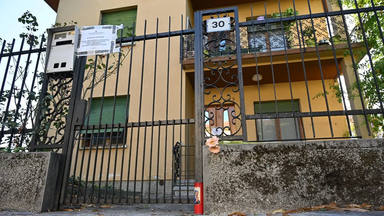 Davanti alla porta di casa qualcuno ha lasciato fiori e un lumino (Foto Petrussi)