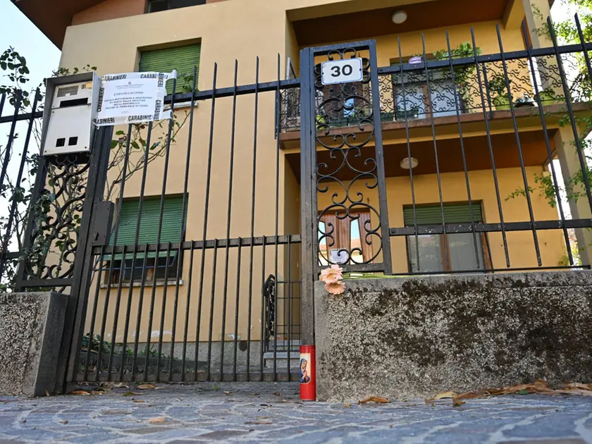 Davanti alla porta di casa qualcuno ha lasciato fiori e un lumino (Foto Petrussi)