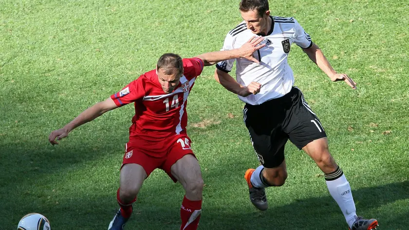Germany's Miroslav Klose (R) and Serbia's Milan Jovanovich (L) during the FIFA World Cup 2010 group D preliminary round match between Germany and Serbia at the Nelson Mandela Bay stadium in Port Elizabeth, South Africa, 18 June 2010.