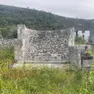 A sinistra il muro perimetrale che rimane della chiesetta, a destra il parroco don Ambrož Kodelja
