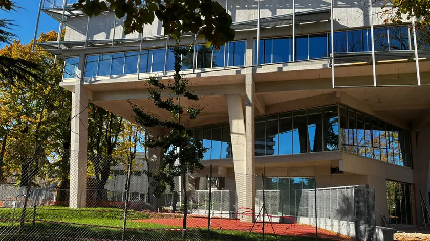 L’assessore Lidia Diomede, Alessandro Ciriani, l’area del cantiere che costeggia la scuola