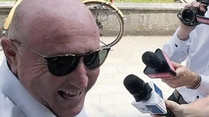 Mauro Lovisa sorridente davanti ai microfoni, dopo l’udienza