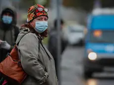 epa08750280 Russian people wearing a protective face masks waiting a bus on the bus stop in Moscow, Russia, 15 October 2020. According to official information, in the past 24 hours Russia registered 15150 included 5049 in Moscow new cases caused by the SARS-CoV-2 coronavirus infection. EPA/YURI KOCHETKOV
