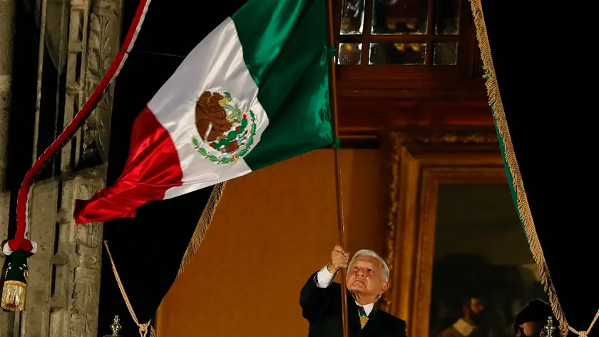 epa11607537 Outgoing Mexican President, Andres Manuel Lopez Obrador, waves the national flag as he leads the 214th anniversary of Independence Shout from the balcony of the National Palace in Mexico City, Mexico, late 15 September 2024. Obrador led his sixth and last Independence Shout as President, as his successor, president-elect Claudia Sheinbaum, will take office on 01 October. EPA/Mario Guzman