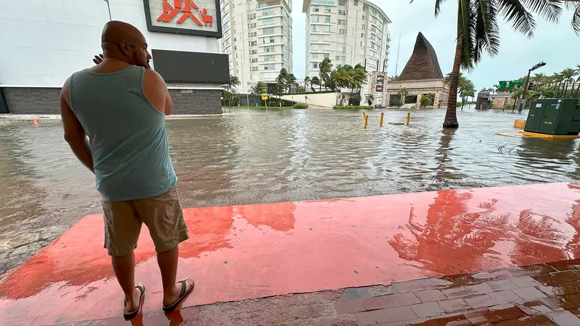 epa11625169 A man observes a street flooded by Hurricane Helene in the beach resort of Cancun, Quintana Roo, Mexico, 25 September 2024. The northern part of the state of Quintana Roo in southern Mexico was hit by Hurricane Helene, which intensified to a category 1 hurricane in the Caribbean Sea as it heads towards the United States. EPA/Alonso Cupul