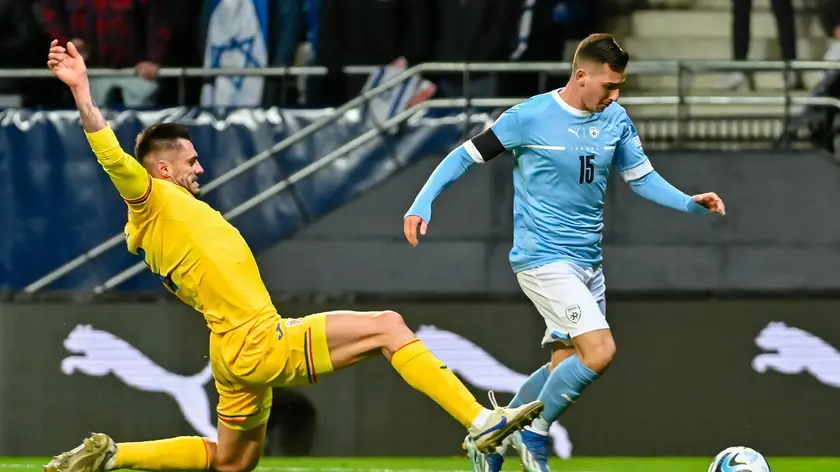 epa10983529 Israel’s Oszkar Glouh (R) in action against Romania's Andrei Burca during the UEFA EURO 2024 Group I qualifying soccer match between Israel and Romania in Felcsut, Hungary, 18 November 2023. EPA/Tamas Vasvari HUNGARY OUT