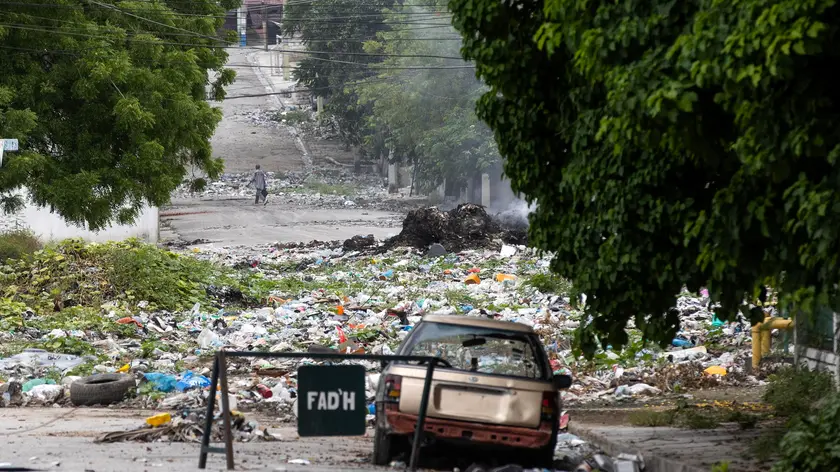 epa11364770 A man walks past debris littering a street in the Bel Air neighborhood in Port-au-Prince, Haiti, 23 May 2024. Kenya has committed to leading an international security support mission to put a stop to the armed gangs that share control of a large part of the country's main cities, starting with Port-au-Prince, which this week was able to reopen its airport, about three months after being forced to shut due to deadly gang-related violence. The mission is the result of a resolution of the United Nations Security Council, has the financial support of the United States and will be subject to the control of the Haitian National Police. EPA/ORLANDO BARRIA