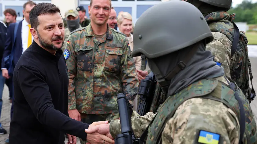 epa11404642 President of Ukraine Volodymyr Zelensky (L), welcomes Ukrainian soldiers during his visit to a military training ground to learn about the training of Ukrainian soldiers on the 'Patriot' air defense missile system in Germany, 11 June 2024. Ukrainina President visits Germany to take part in The Ukraine Recovery Conference 2024 that takes place in Berlin from 11 to 12 June 2024, under the slogan 'United in defense. United in recovery. Stronger together.' EPA/JENS BUETTNER / POOL