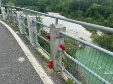 Sulla ringhiera del ponte Romano sono apparsi fiori e alcune rose rosse