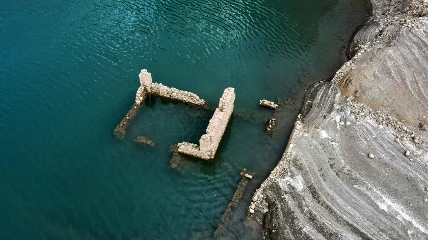 epaselect epa11576499 The remains of a building of the sunken village of Kallio is revealed due to the receding water level of Mornos artificial lake, near the village of Lidoriki in the prefecture of Fokida, about 240 km northwest of Athens, Greece, 29 August 2024 (issued 31 August 2024). Over the past two years, the level of Mornos artificial lake, which serves as a water supply to the capital Athens, has receded more than 35 meters, with approximately 18 just in the past year, according to local residents. In 1980 when the Mornos lake was completed by constructing a dam on the Mornos River, 80 houses along with their church and primary school of the village of Kallio, were evacuated and submerged in the water for the lake to be created. Nowadays, the few residents living around the lake observe with alarm every day how the buried village emerges, along with their childhood memories and everything they left behind. EPA/ALEXANDROS REMOUNDOS