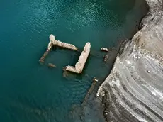 epaselect epa11576499 The remains of a building of the sunken village of Kallio is revealed due to the receding water level of Mornos artificial lake, near the village of Lidoriki in the prefecture of Fokida, about 240 km northwest of Athens, Greece, 29 August 2024 (issued 31 August 2024). Over the past two years, the level of Mornos artificial lake, which serves as a water supply to the capital Athens, has receded more than 35 meters, with approximately 18 just in the past year, according to local residents. In 1980 when the Mornos lake was completed by constructing a dam on the Mornos River, 80 houses along with their church and primary school of the village of Kallio, were evacuated and submerged in the water for the lake to be created. Nowadays, the few residents living around the lake observe with alarm every day how the buried village emerges, along with their childhood memories and everything they left behind. EPA/ALEXANDROS REMOUNDOS