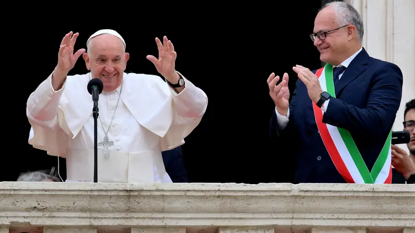 Pope Francis (L) is flanked by Rome's Mayor Roberto Gualtieri, blesses the faithful from a balcony during his visit to Campidoglio (Capitoline hill) in Rome, Italy, 10 June 2024. ANSA/ETTORE FERRARI
