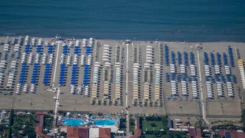 Una veduta delle spiagge e stabilimenti balneari della Versilia nel ponte di Ferragosto, durante un'operazione di controllo del territorio della Polizia di Stato con l’elicottero dell’8 reparto volo di Firenze, 16 Agosto 2024 ANSA/CLAUDIO GIOVANNINI ( mare, vacanze, vacanza, estate, spiaggia, ombrelloni, caldo , litorale, turisti, turismo, generica ) ---- A view of the beaches and bathing establishments of Versilia (Italy) in the mid-August holiday weekend, during a control operation of the territory of the State Police with the helicopter of the 8th flight department of Florence, 16 August 2024 ANSA/CLAUDIO GIOVANNINI (sea, holidays, holiday, summer, beach, umbrellas, hot, coast, tourists, tourism, generic)