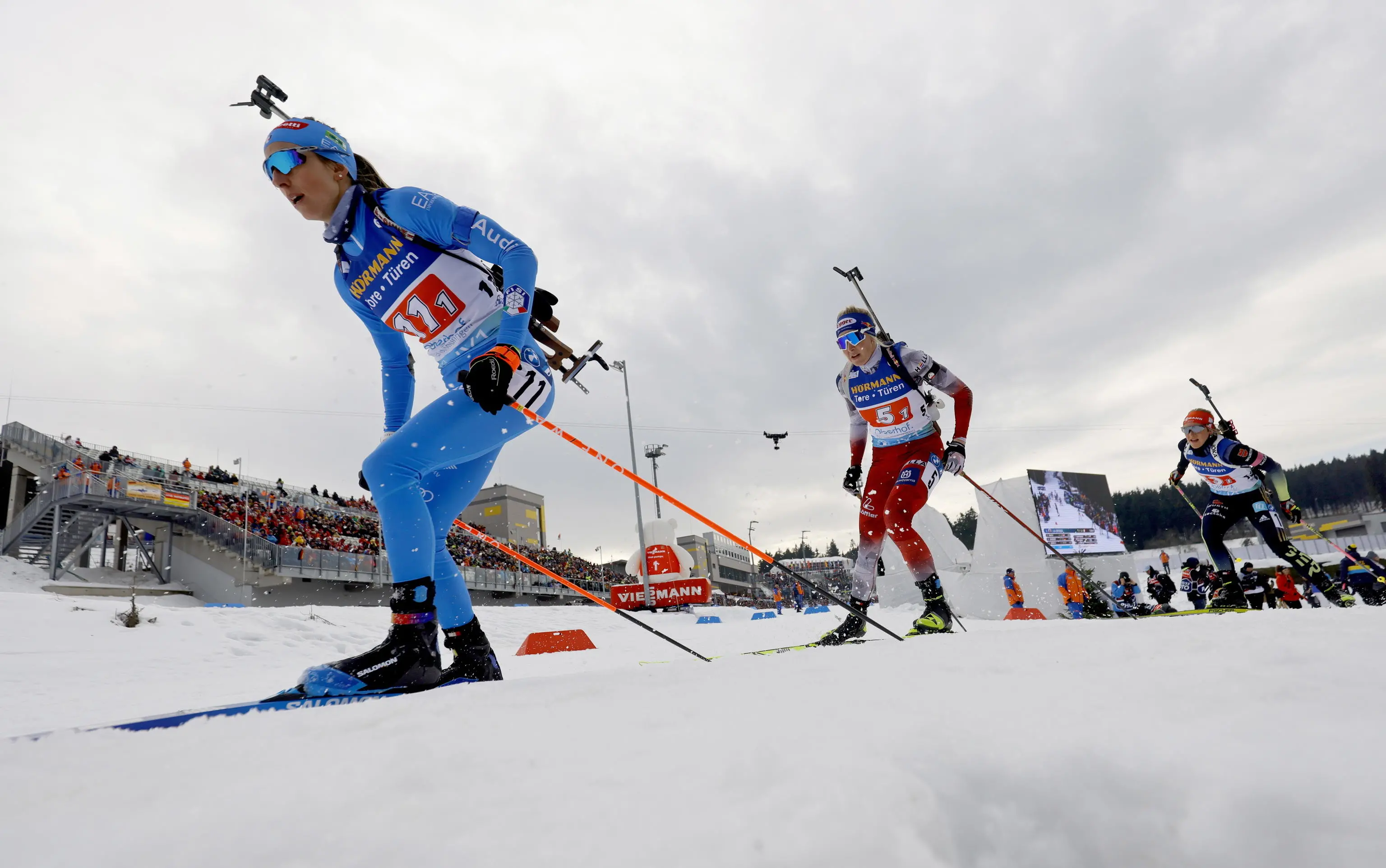 epa10470730 Lisa Vittozzi (L) of Italy and Lisa Theresa Hauser (C) of Austria in action during the Single Mixed Relay race at the IBU Biathlon World Championships in Oberhof, Germany, 16 February 2023. EPA/RONALD WITTEK