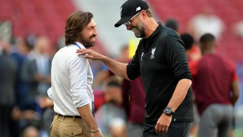epa07615682 Liverpool's manager Juergen Klopp (R) is greeted by former Italian player Andrea Pirlo (L) during his team's training session at the Wanda Metropolitano stadium in Madrid, Spain, 31 May 2019. Liverpool FC will face Tottenham Hotspur in the 2019 UEFA Champions League final at the Wanda Metropolitano stadium in Madrid, Spain, on 01 June 2019. EPA/PETER POWELL