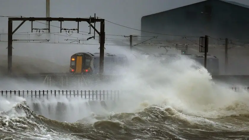 epa04006815 A train passes along the coast at Saltcoats in Scotland which is battered by big sea waves 3 January 2014 as Britain is braced for the worst as a combination of high tides, heavy rains and strong winds are expected to bring yet more severe flooding to parts of the country. EPA/Danny Lawson UK and Republic of Ireland Out EDITORIAL USE ONLY EDITORIAL USE ONLY