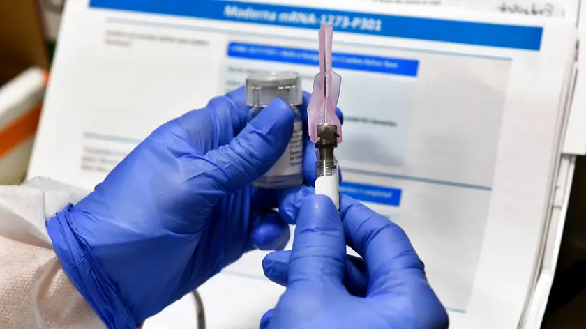 FILE - In this July 27, 2020, file photo, nurse Kathe Olmstead prepares a shot that is part of a possible COVID-19 vaccine, developed by the National Institutes of Health and Moderna Inc., in Binghamton, N.Y. Moderna said Monday, Nov. 16, 2020, its COVID-19 shot provides strong protection against the coronavirus that\'s surging in the U.S. and around the world. (AP Photo/Hans Pennink, File)
