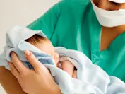 A medical practitioner holding a newborn baby --- Image by © I Love Images/Corbis