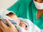 A medical practitioner holding a newborn baby --- Image by © I Love Images/Corbis