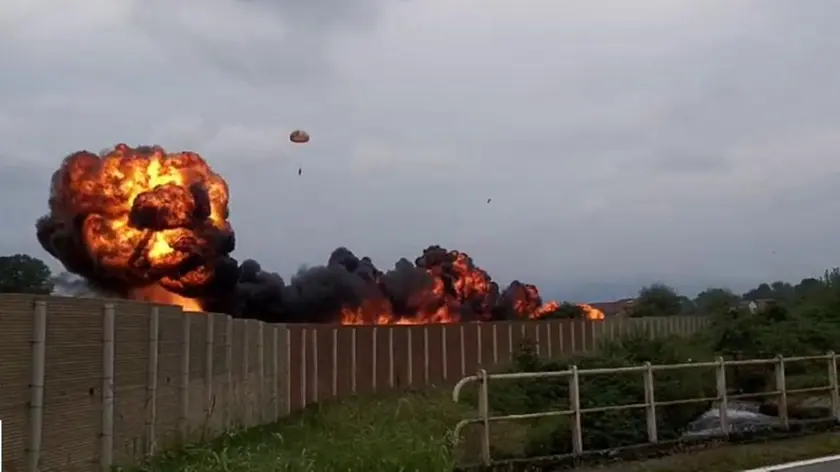 L'impressionante immagine con la scia di fuoco lasciata dall'aereo dopo lo schianto a terra e il pilota lanciatosi con il paracadute prima dell'impatto