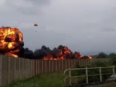 L'impressionante immagine con la scia di fuoco lasciata dall'aereo dopo lo schianto a terra e il pilota lanciatosi con il paracadute prima dell'impatto