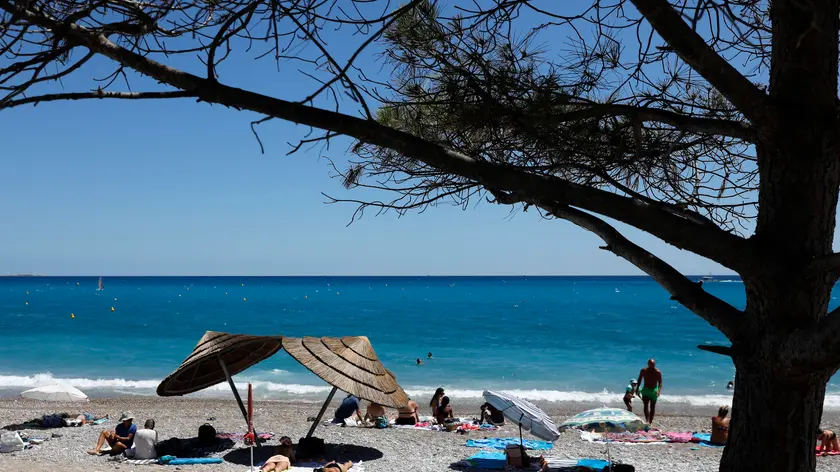 epa10789075 People enjoy the sun on a beach in Antibes, France, 07 August 2023. Temperatures reached up to 28 Celcius degrees in Nice. EPA/SEBASTIEN NOGIER