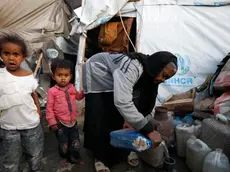 epa10541342 Yemeni children stand next to their grandmother at a makeshift camp for Internally Displaced Persons (IDPs) in Sana'a, Yemen, 23 March 2023 (issued 24 March 2023). More than 11 million children in Yemen require urgent humanitarian aid as they could face greater risks of malnutrition due to the consequences of eight years of the endless and crushing war in the Arab country, the United Nations Children's Agency (UNICEF) has warned. The protracted war in Yemen is referred to as the Saudi Arabia-Iran proxy conflict in which the warring parties have been militarily and politically backed by Saudi Arabia and Iran respectively since 2015. EPA/YAHYA ARHAB