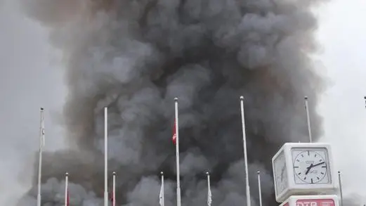 epa03815819 Smoke rises from the arrival terminal of the Jomo Kenyatta International Airport in Nairobi after a blaze, Nairobi, Kenya, 07 August 2013. A major fire forced the closure of Nairobi's main international airport early 07 August as crews battled the blaze which engulfed an entire terminal building. Parts of the roof of terminal 1 at Jomo Kenyatta International Airport collapsed in the fire, making it more difficult for fire crews to battle the blaze, which began in the early morning. EPA/STR