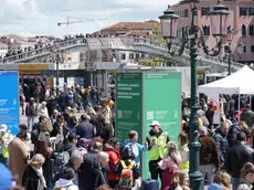 Operatori ai varchi controllano il ticket di accesso sul telefonino dei turisti, al check point del piazzale della stazione ferroviaria di Venezia