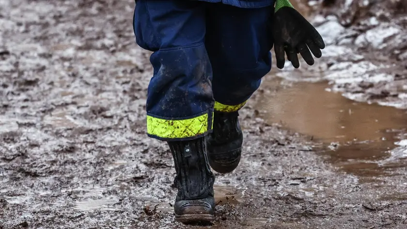 epa11057147 A fireman walks in mud in Sangerhausen, hit by flooding of the Helme river, in Sangerhausen, Germany, 04 January 2024. Olaf Scholz travels to different areas in Germany devastated and threatened by current flooding. Thousands of emergency forces are engaged in securing and rescue operations in Germany. EPA/FILIP SINGER