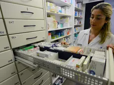 Una farmacista con un cassetto di medicinali aperto in una farmacia a Pontedera, Pisa, 10 luglio 2012. ANSA/STRINGER