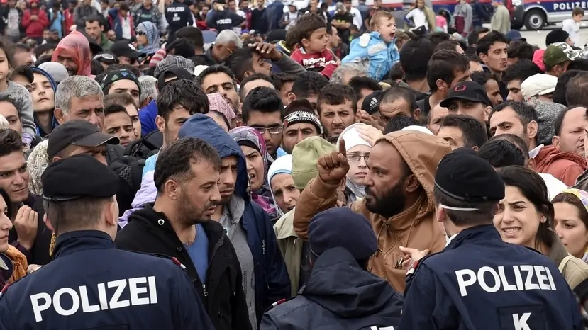 epa04930278 Austrian police directs refugees waiting for busses at a reception camp at the Austrian-Hungarian border in Nickelsdorf, Austria, 14 September 2015. Austria's army will be deployed at the border with Hungary to assist police, Austrian Chancellor Werner Faymann said, while making clear that Austria will continue to let in refugees. EPA/HERBERT P. OCZERET