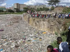 epa11474629 Onlookers watch as bodies wrapped in bags are being retrieved from inside a quarry turned into a dump site at Embakasi area in Nairobi, Kenya, 12 July 2024. Police stated that six severely mutilated female bodies, in various stages of decomposition and wrapped in nylon bags and ropes, were recovered from the former quarry near Mukuru Kwa Njenga slum in Nairobi. Police said the area has been declared a crime scene and an investigation is underway. EPA/STRINGER
