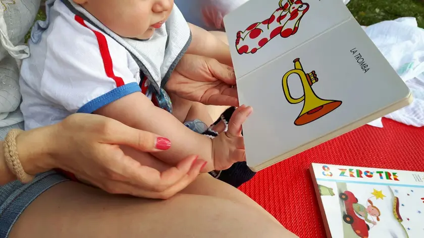 Un bimbo intento a sfogliare un libro (foto di archivio)