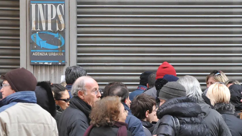 Fila di utenti ad uno sportello Inps di Napoli in attesa dell'apertura delgli uffici per la presentazione delle domande di pensione in una foto di archivio. ANSA/CIRO FUSCO